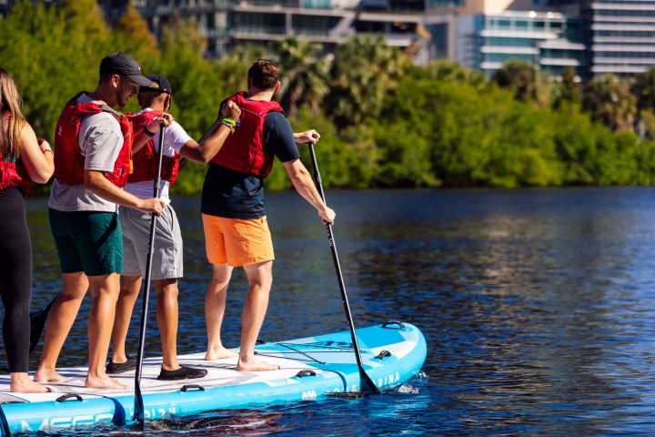 a group of people standing next to a body of water
