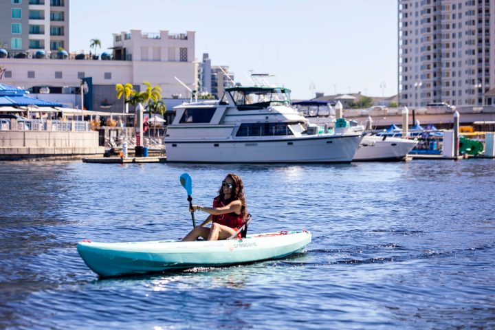 a small boat in a body of water with a city in the background